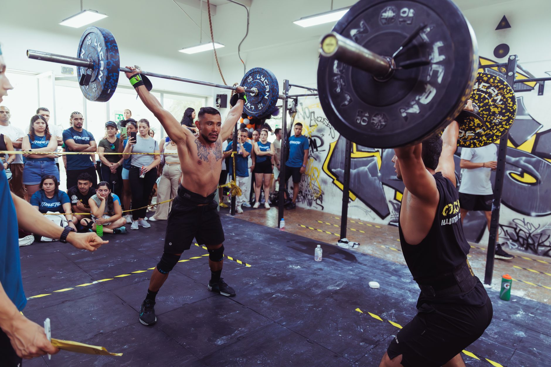 Action-packed scene of athletes lifting weights at a CrossFit event in Pereira, Colombia.