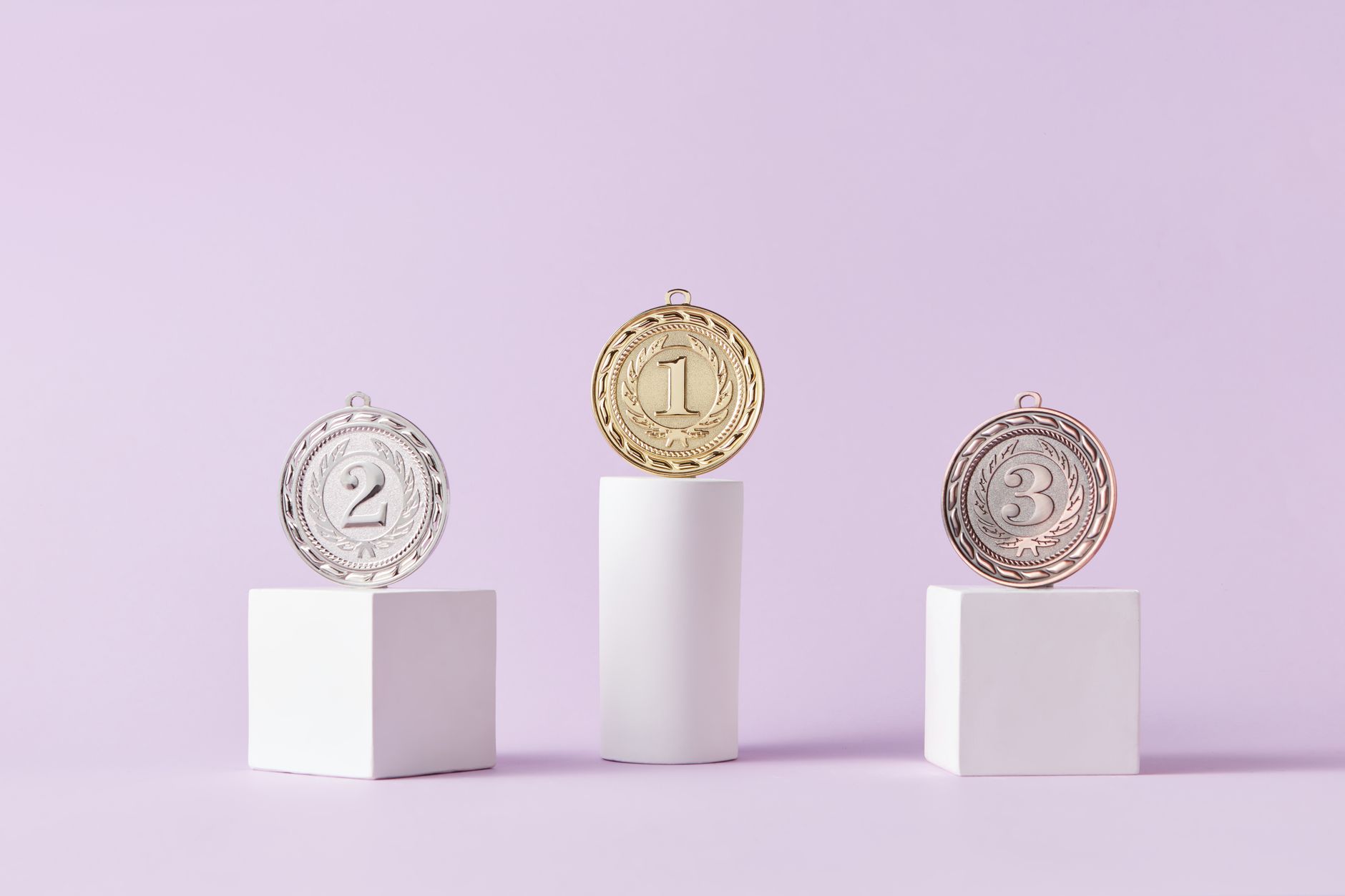 Medals on a podium against a soft pastel background, ideal for awards themes.