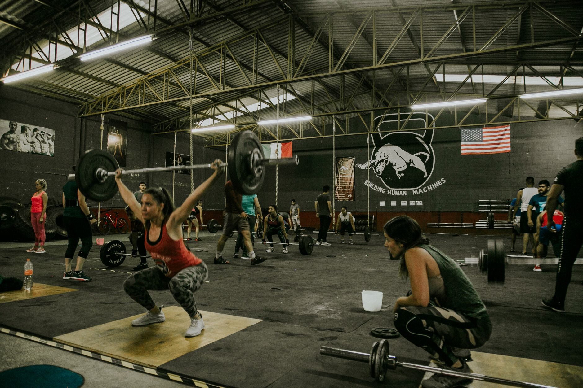 Diverse group engaging in CrossFit training in an industrial-style gym.