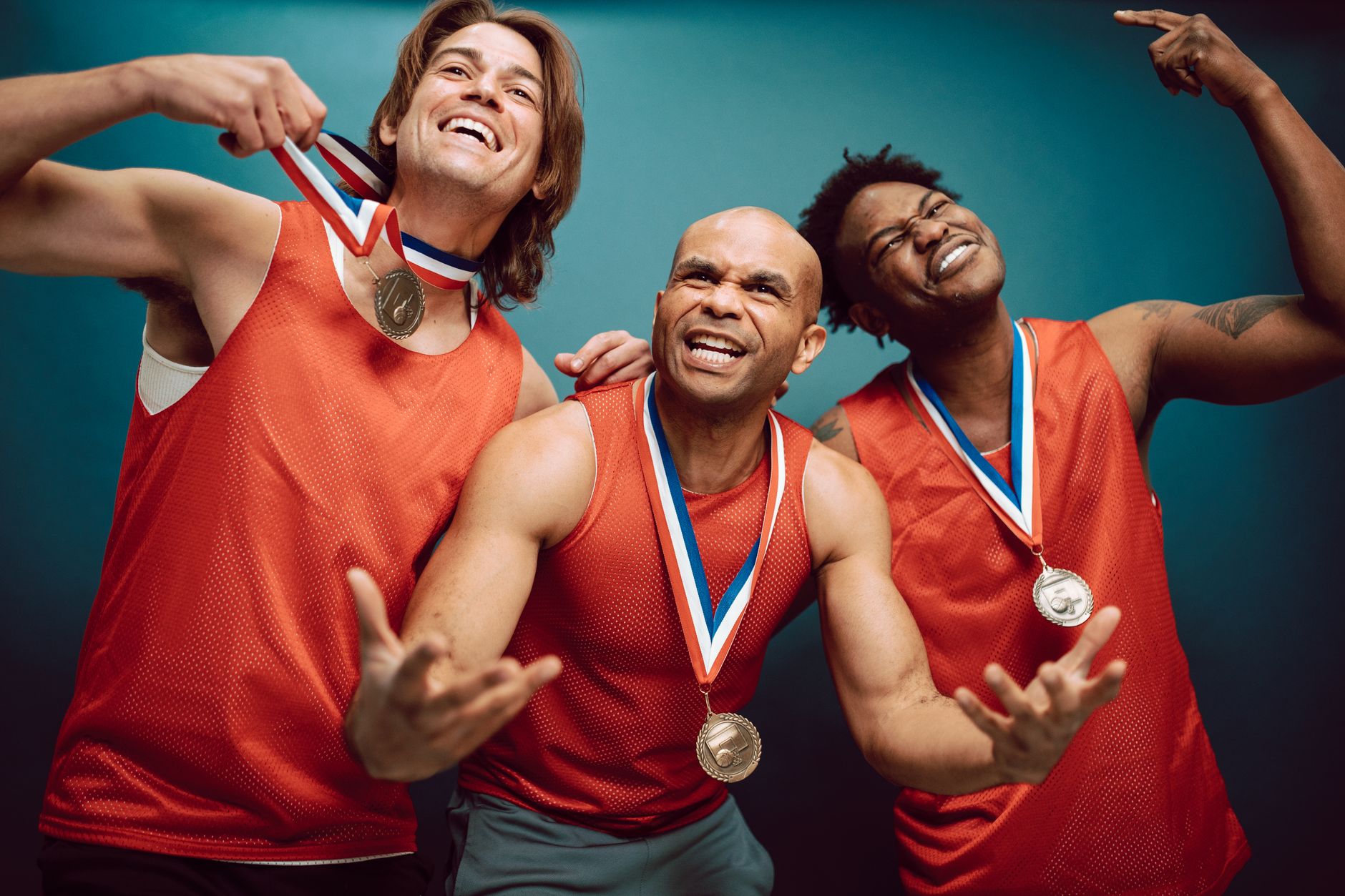 Three athletes celebrate with medals, showcasing teamwork and success.