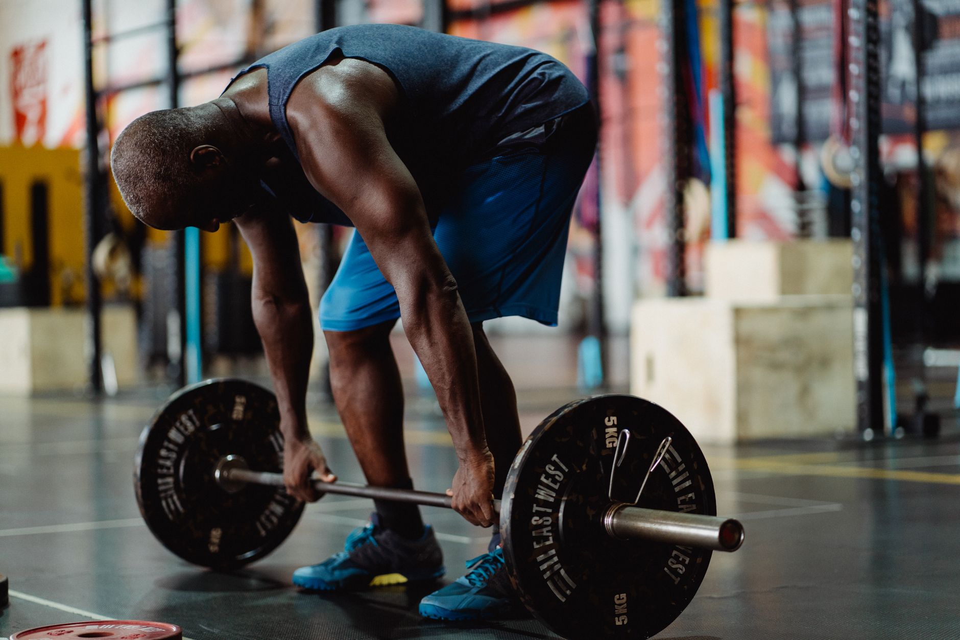 Man performing deadlifts in a modern gym, showcasing strength and fitness.